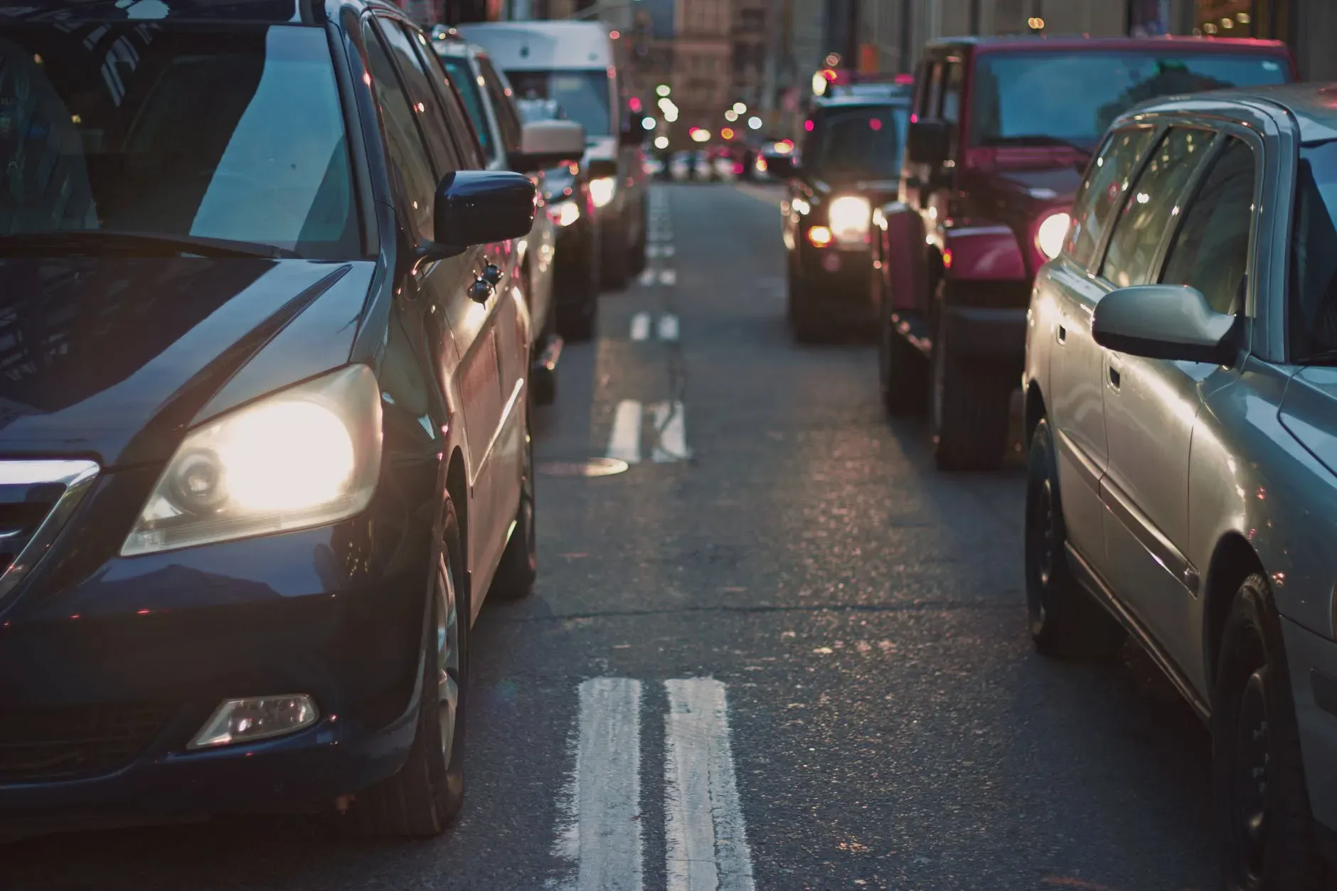 A imagem mostra um acúmulo de diversos carros na rua, o trânsito.